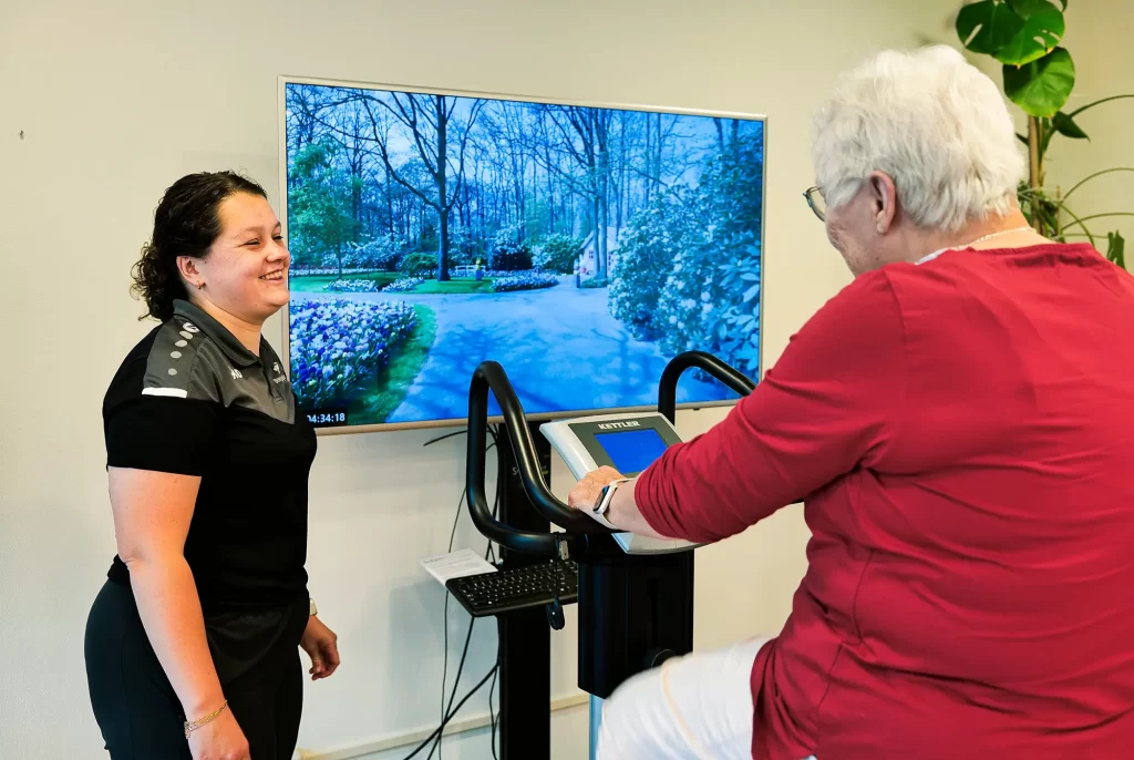 Virtueel fietsen met de SilverFit Mile op een hometrainer met realistische routes op groot scherm.